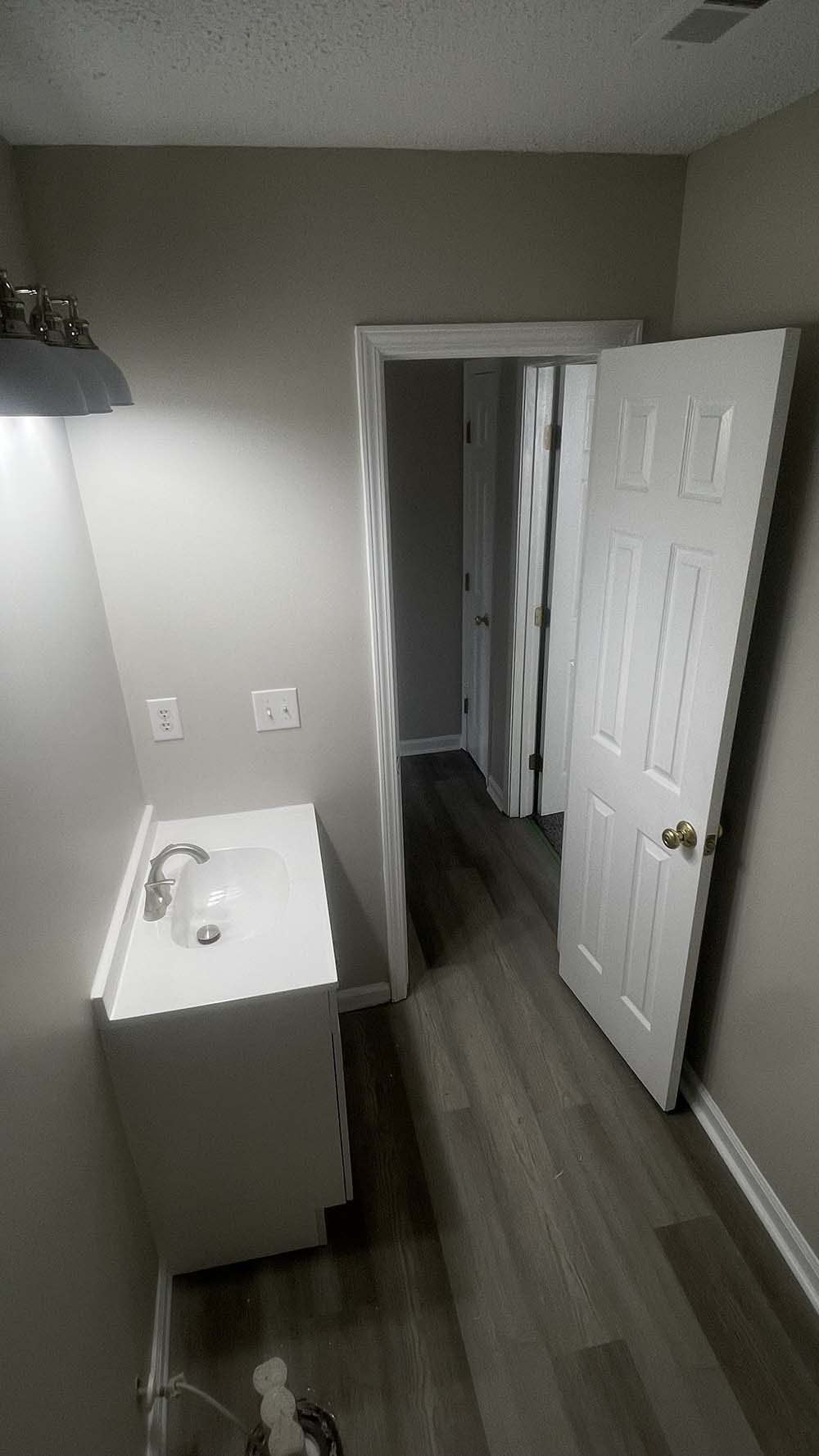 Finished bathroom showing vanity, custom-mortised door, and clean trim finish